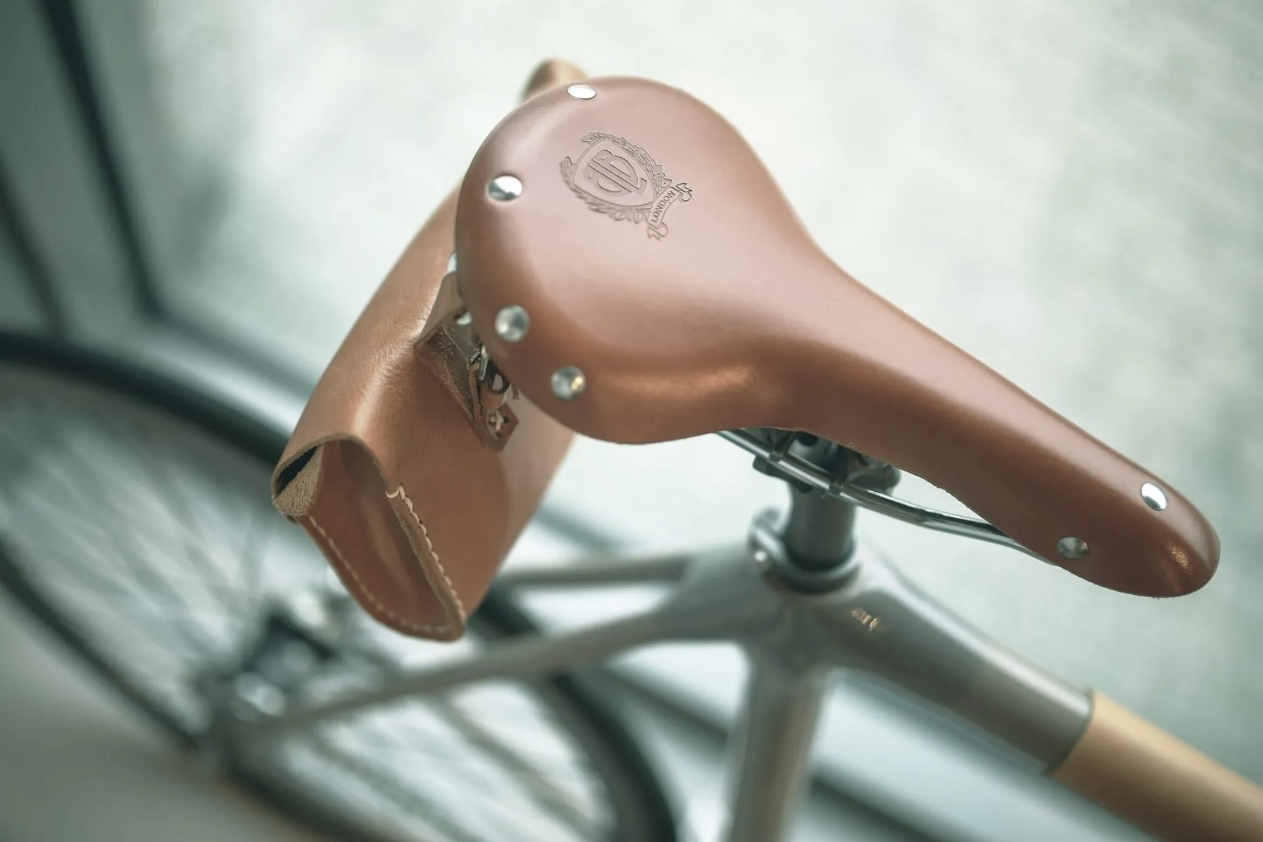 Gros plan sur une selle en cuir et un guidon de vélo, dans l'esprit artisanal de l'atelier.